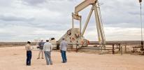 Inspectors in front of a pump jack